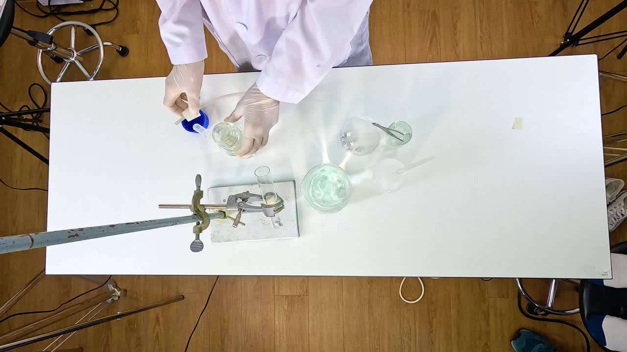 A scientist conducts a thermal decomposition experiment with copper carbonate using lab equipment on a white table