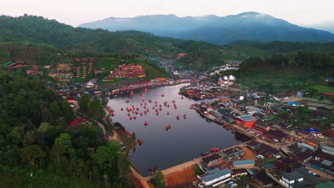 drone fly misty village in thailand ban rat thai, lake with chinese style boats sailing landscape