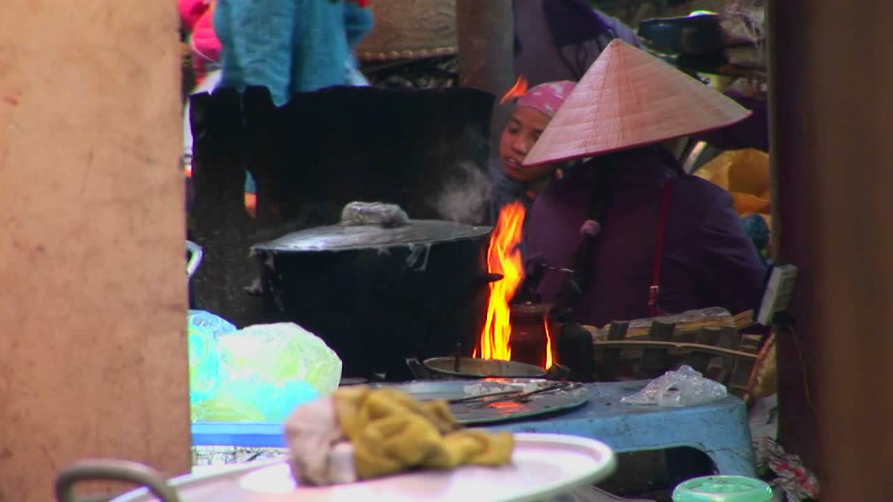 베트남 마을 사람들이 식사를 준비하면서 불이 타고 냄비가 끓고 있다