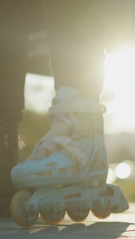 a close-up shot of a person wearing a rollerblade on one foot, with the wheels in motion, stepping on the ground in a park . the other foot is in a black boot, and another black boot is placed nearby