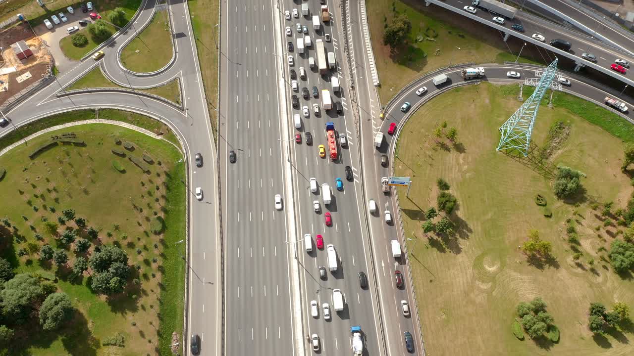 큰 고속도로 오버버, 출구와 교통 체증, 드론에서 위에서 아래로 공중 전망, 큰 도시 생활 일상, 빛, 초록색 심기 지역, 카메라가 서서히 도로 위로 나아가고 차를 아 내려다보고 있습니다.