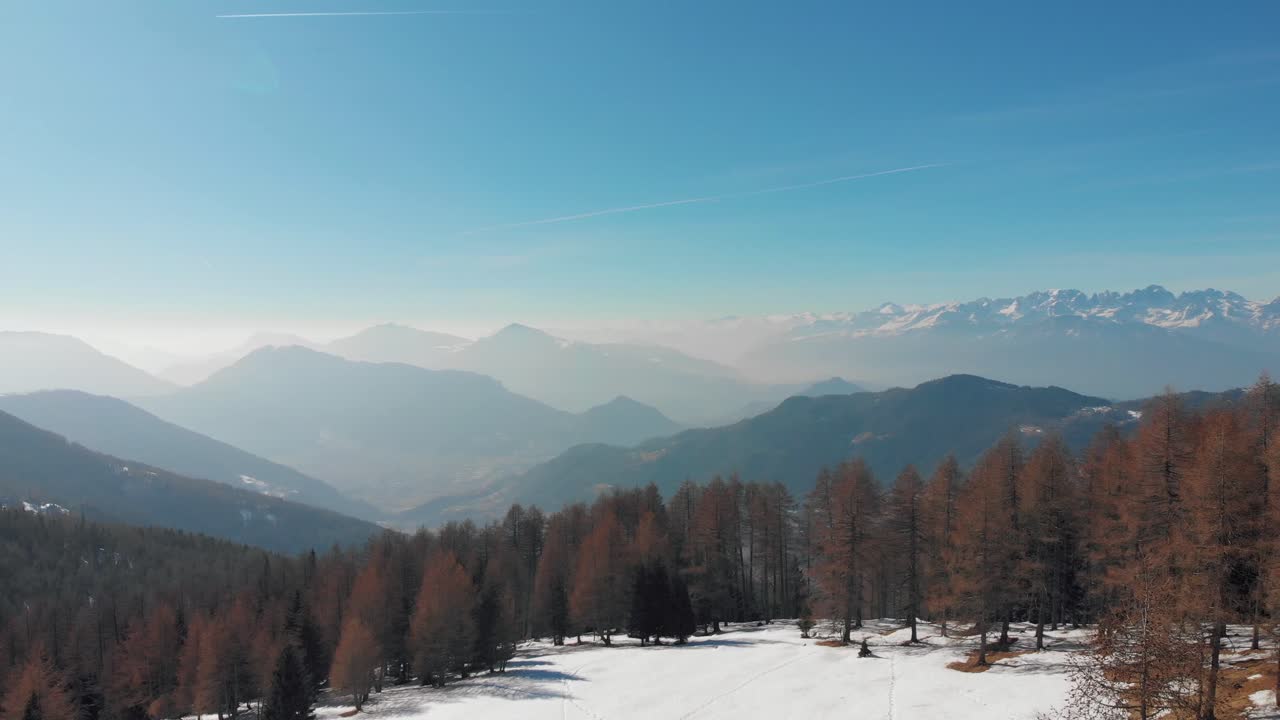 Aerial drone shot of Valle dei Mòcheni and Valsugana from a mountain field near Fierozzo during a hot spring day, Trentino, Italy