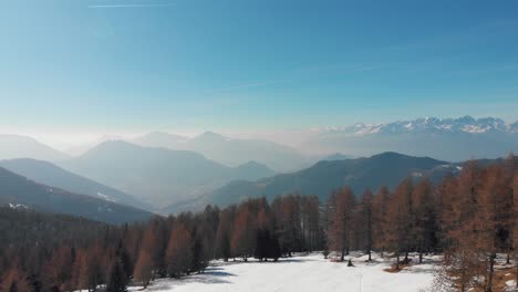 Aerial drone shot of Valle dei Mòcheni and Valsugana from a mountain field near Fierozzo during a hot spring day, Trentino, Italy