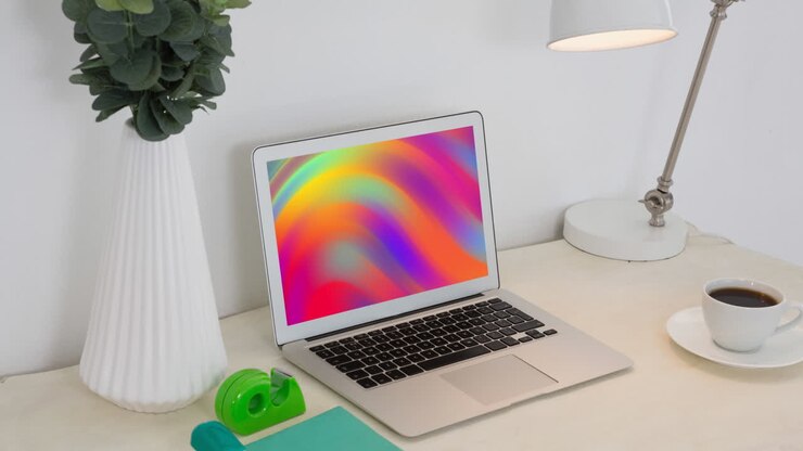 Animation of laptop with colorful moving shapes on screen on desk