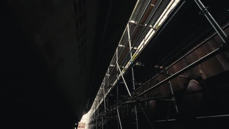 looking up at a scaffold system that goes around the exterior of an old ship