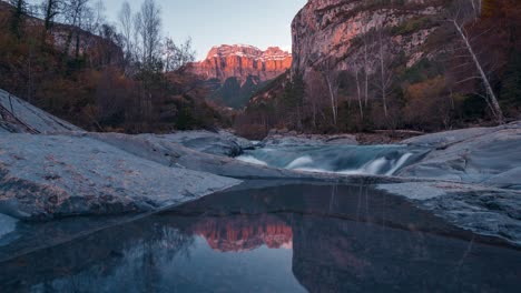 Spiegelung-Eines-Kleinen-Sees-Im-Mondarruego-Nationalpark-Im-Ordesa-Nationalpark,-Der-Die-Letzten-Sonnenstrahlen-Während-Des-Sonnenuntergangs-Im-Zeitraffer-Der-Herbstsaison-Einfängt