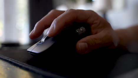 Man-clicking-wireless-black-mouse-at-desk-while-searching-the-web-4k