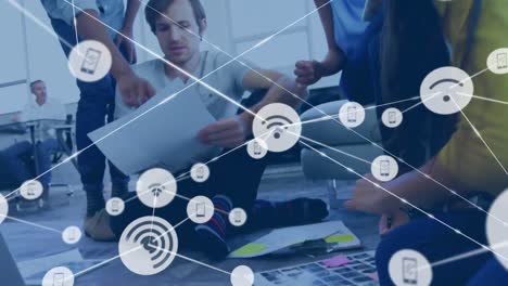 animación de una red de iconos digitales sobre un equipo de diversos colegas discutiendo en la oficina.