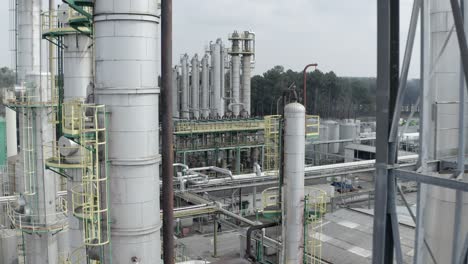 aerial sideways movement past large industrial processing columns and pipes at factory complex, veille-saint-girons, france