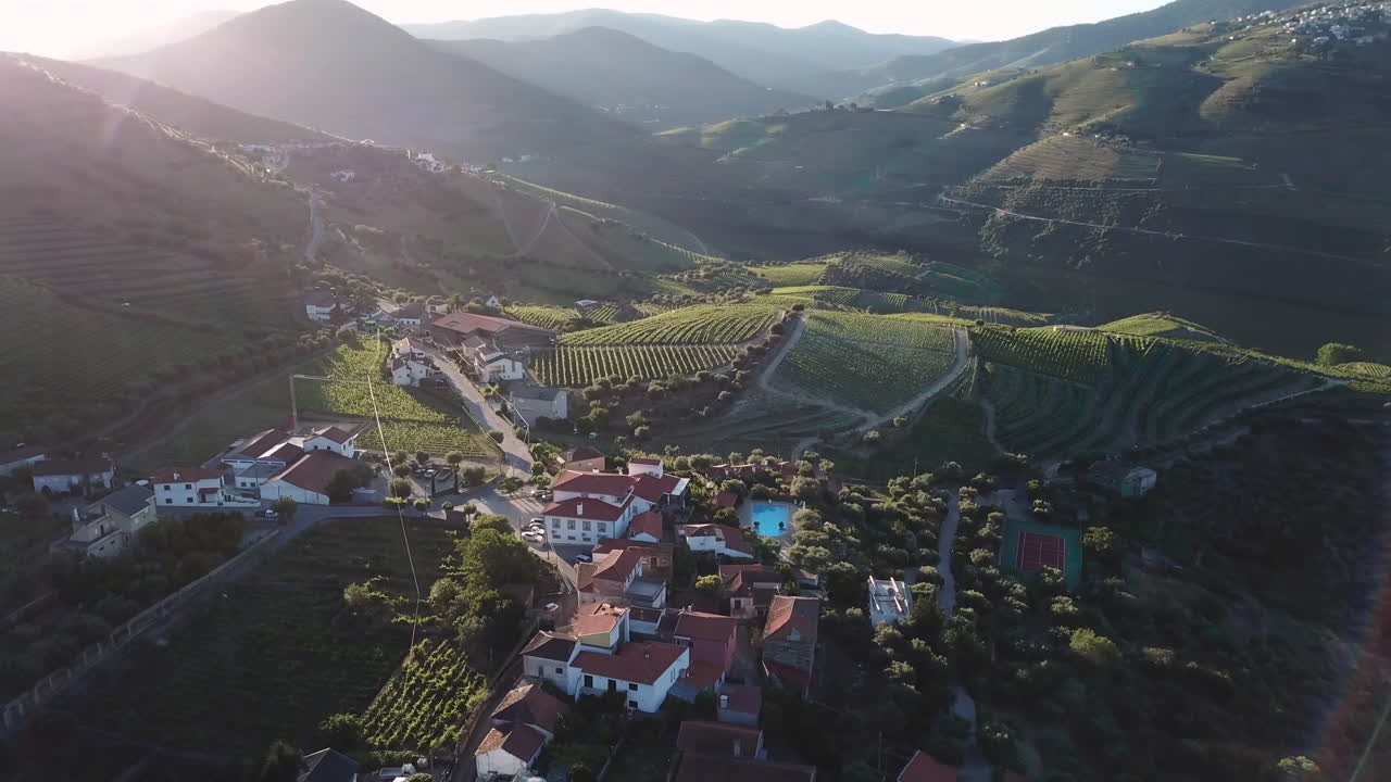 Panoramica pittoresca di una tenuta in cima alla collina nella Valle del Douro in Portogallo, mentre il sole mattutino crea un bellissimo bagliore sull'obiettivo