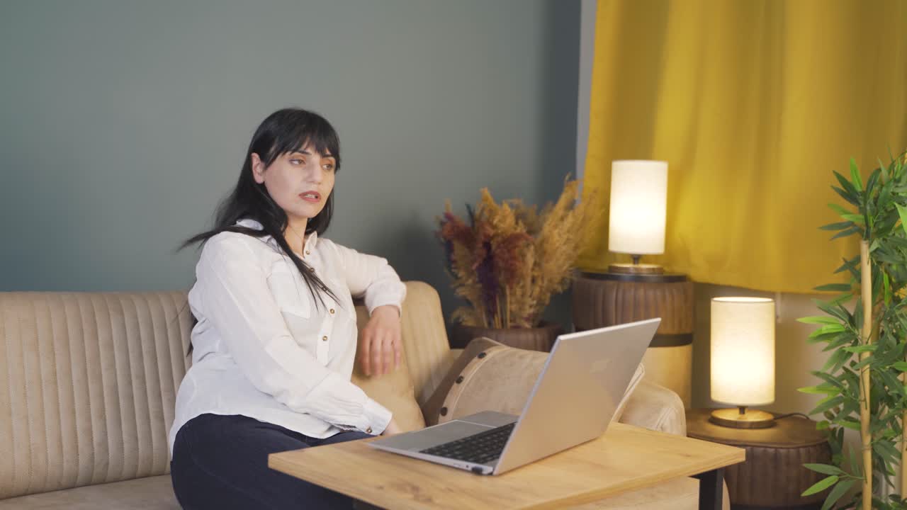 밤에 컴퓨터를 사용하는 동안 피곤해지는 여성.