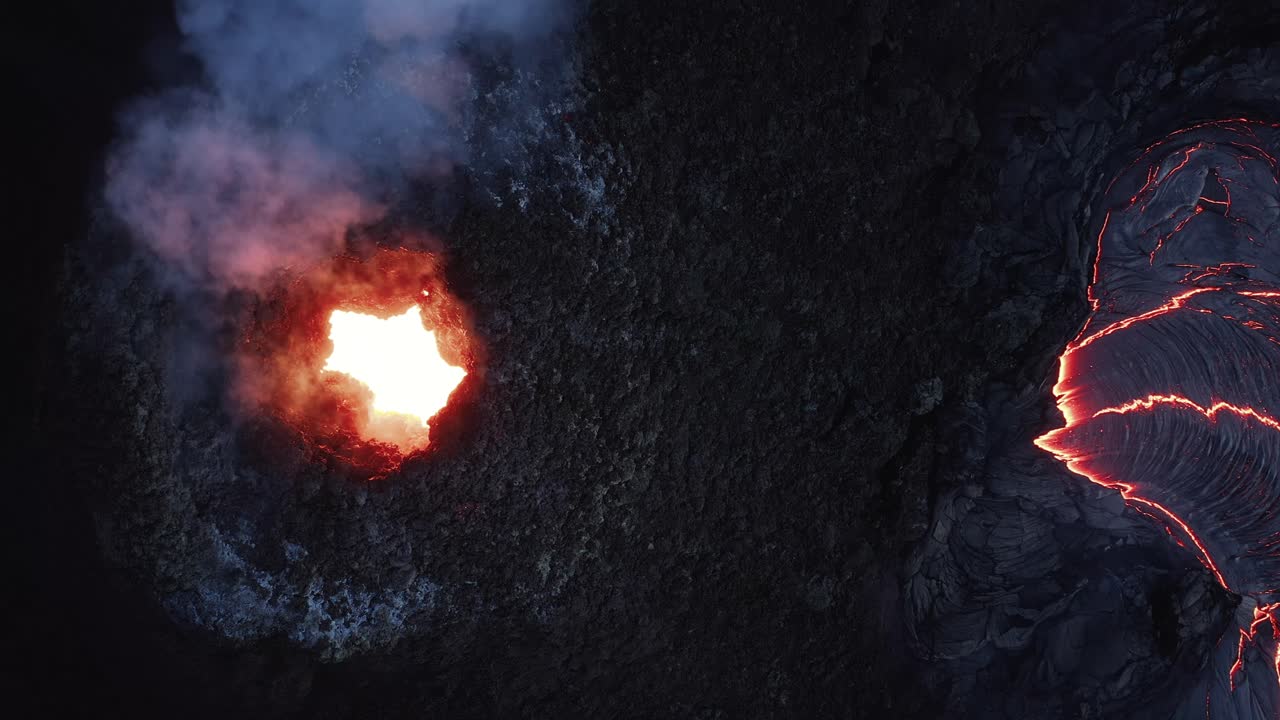 Fiery magma glowing fiercely from hole in volcano crater, top down