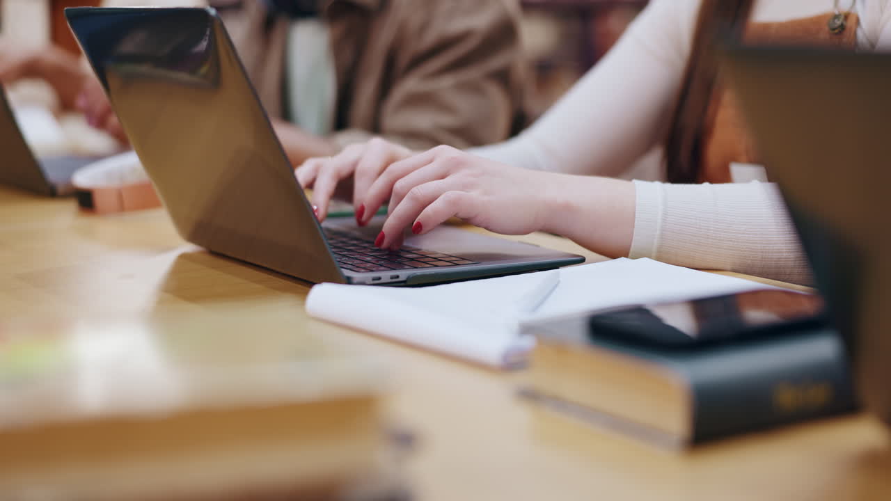 estudiantes trabajando en computadoras portátiles en una biblioteca