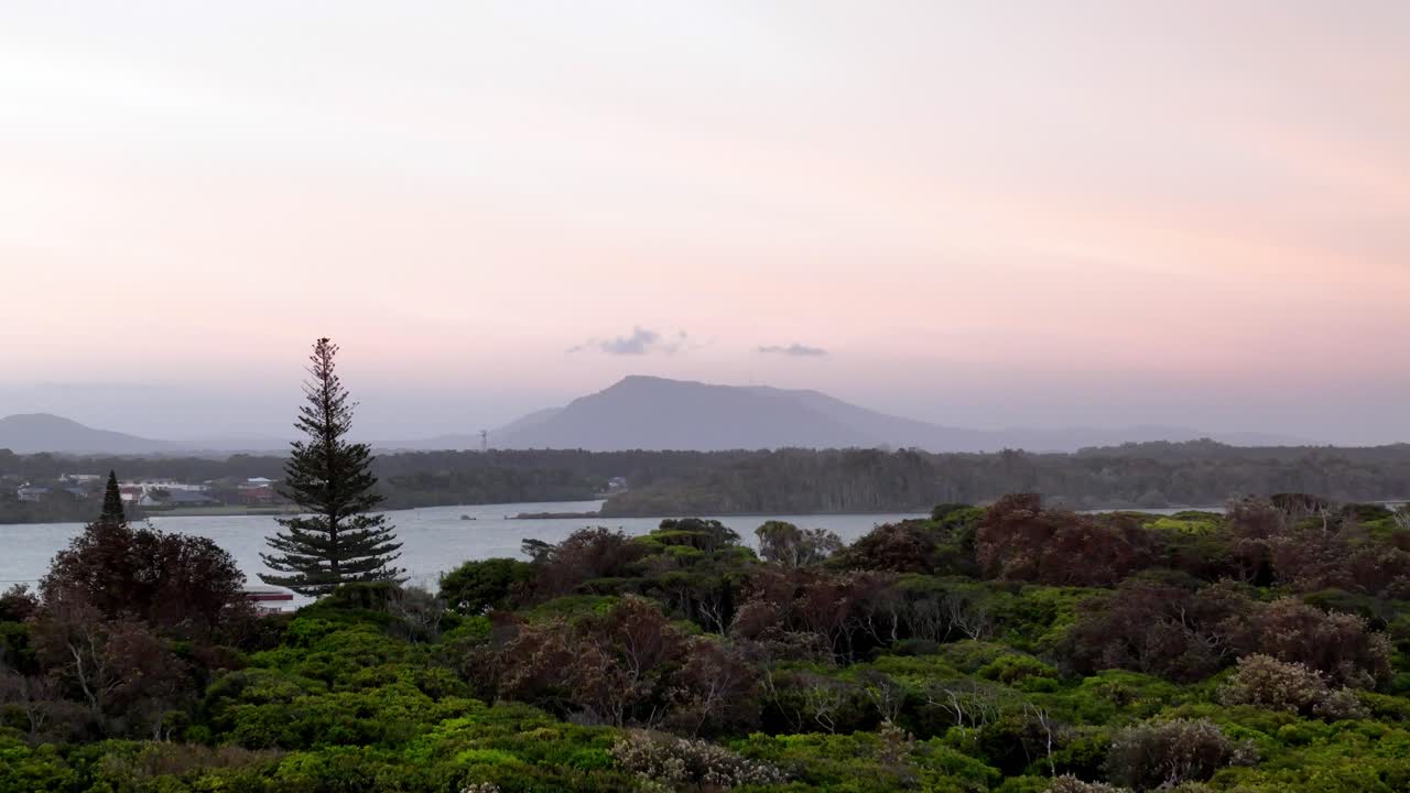 해안 풍경 위의 황혼의 평온함, 파스텔 하늘에 대한 산의 실루