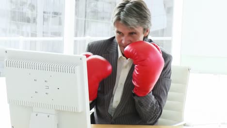un hombre de negocios enojado con guantes de boxeo