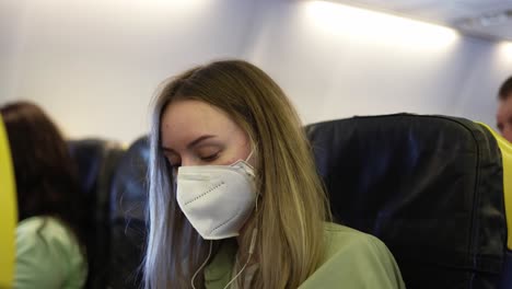 traveller in the airplane putting on earphones to listen to the music