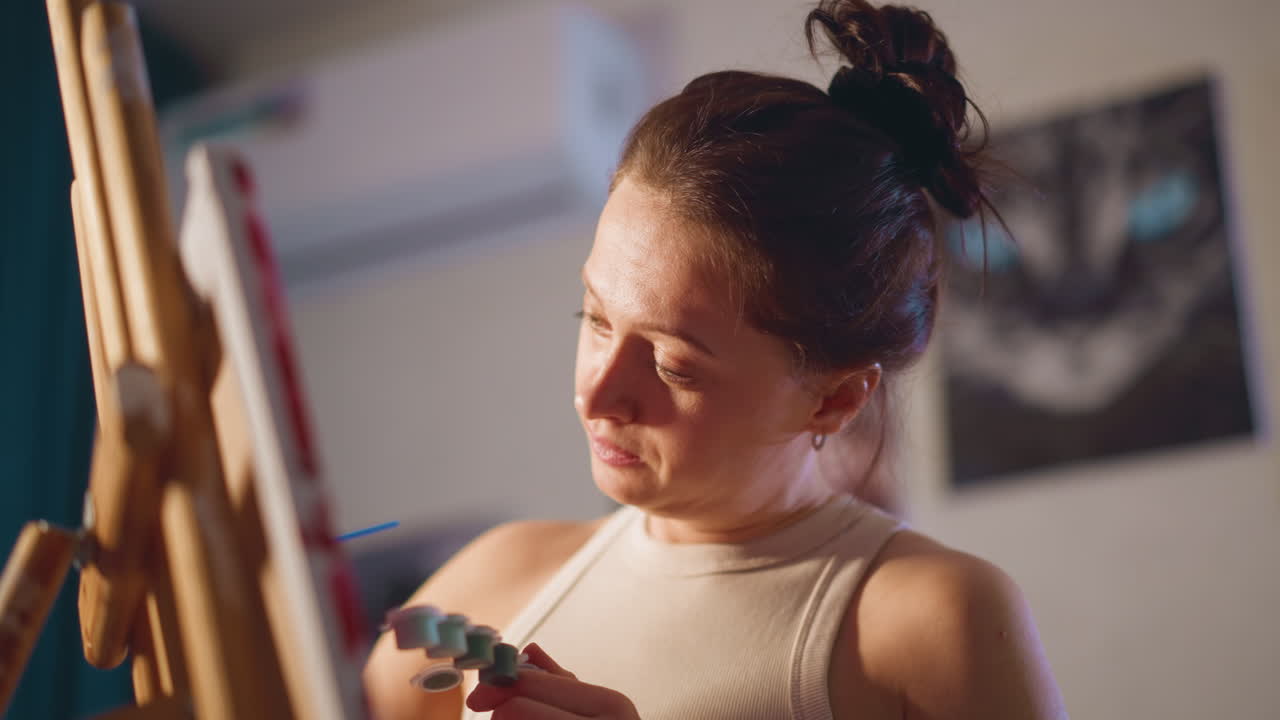 Painter Adds Final Touches Peacefully, Skilled Illustrator Applies Last Details Under Warm Studio Light, Dedicated Artist Delicately Finalizes Painting With Contentment In Cozy Evening Setting