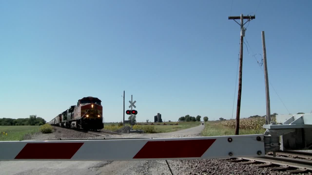 un tren de carga pasa a gran velocidad por un cruce ferroviario cerrado