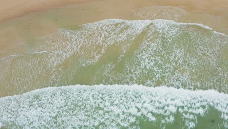 toma aérea de las olas del océano chocando contra una hermosa playa