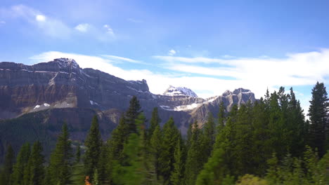 Driving-in-Wilderness-of-Canada-in-Fall-Season,-Colorful-Forest-and-Snowy-Peaks-of-Jasper-National-Park,-Left-Seat-Passenger-POV