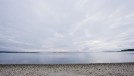 사그 하버 근처의 노아크 베이 (noak bay) 의 평온한 물, 해가 지기 직전, 해변은 매우 바위가 있고, 멀리서 육지가 볼 수 있습니다.