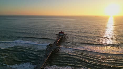 A drone reveal shot of Huntington Beach Pier at sunset, capturing vibrant colors and the scenic California coast.