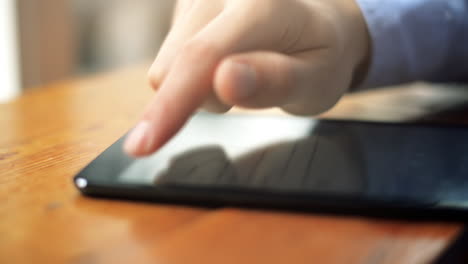 mano de primer plano con pantalla táctil tocando el dedo de la tableta