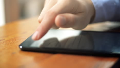 close-up hand using touchscreen touching finger tablet