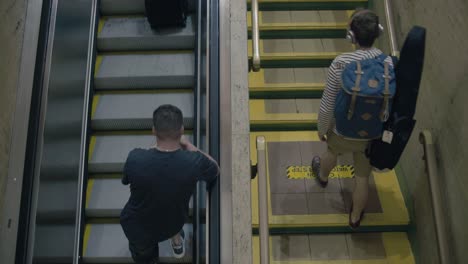 a group of people take an escalator up alongside others that are walking up stairs.