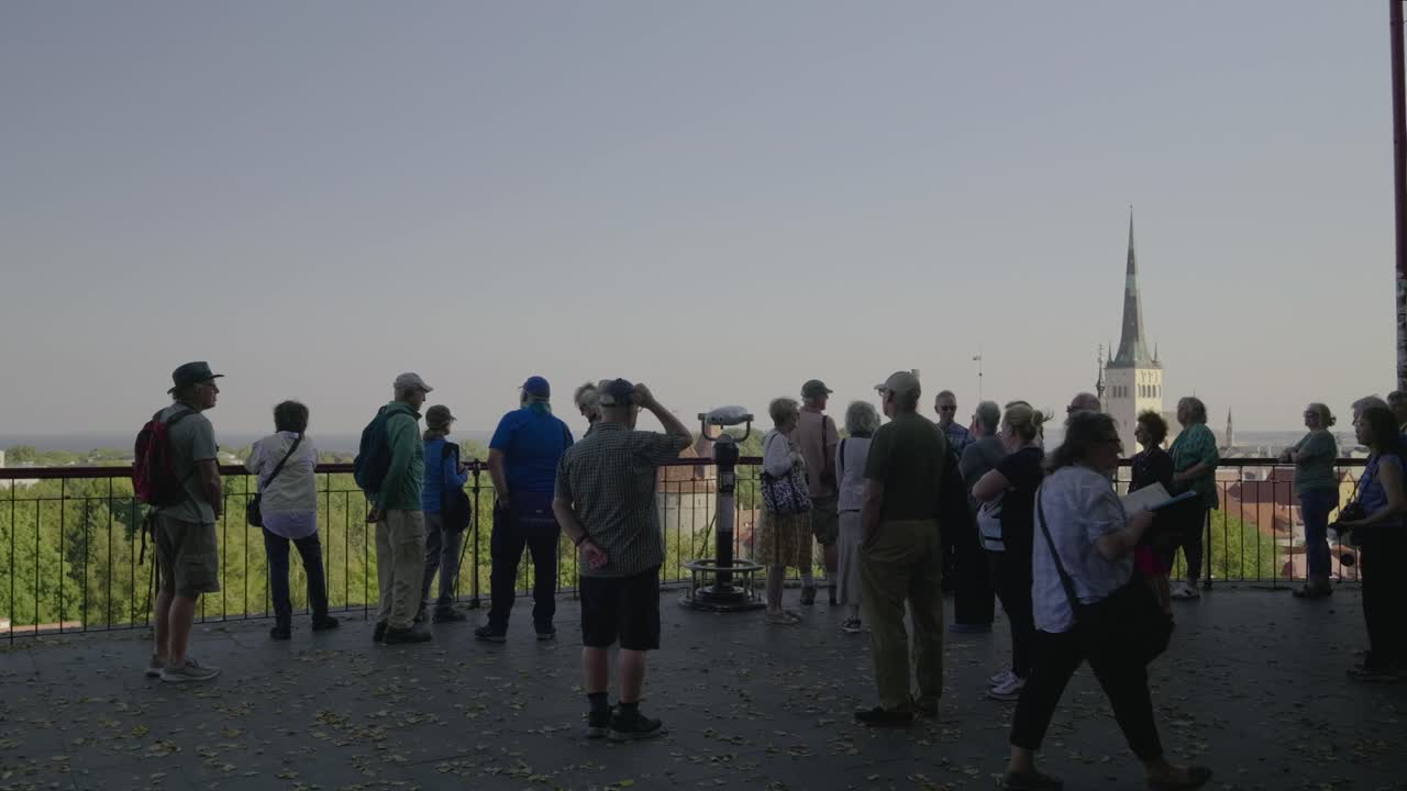 Group of tourists at viewpoint overlooking Tallinn, Estonia with St. Olaf Church