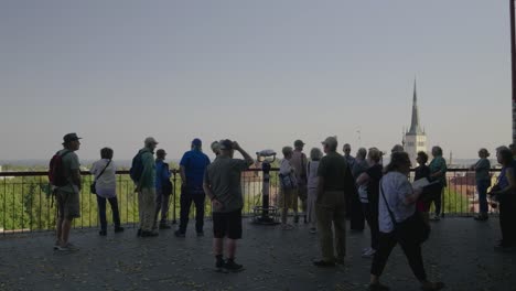 group of tourists at viewpoint overlooking tallinn, estonia with st. olaf church