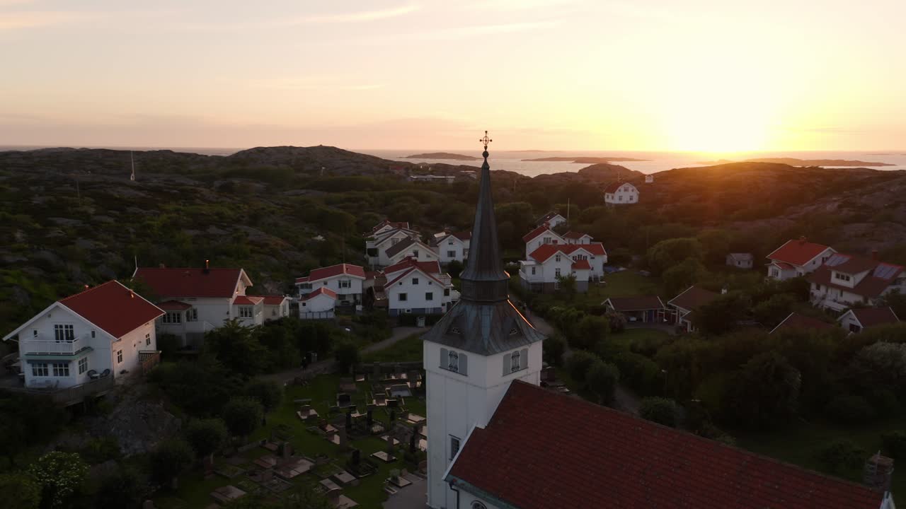 Drone flying over the island of Gullholmen and a Church at sunset or sunrise