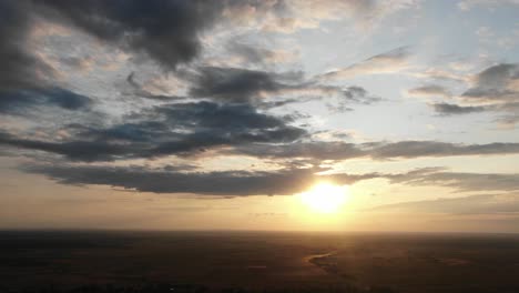 Luftaufnahme-Des-Himmels-Während-Des-Glühenden-Sonnenuntergangs,-Der-Durch-Die-Wolken-In-Der-Landschaft-Osteuropas-Scheint