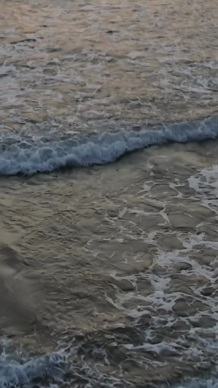 Impronte nella sabbia lungo la spiaggia in Marocco al tramonto