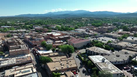 Aerial-view-of-Santa-Fe,-showcasing-the-distinct-adobe-buildings-and-panoramic-mountain-vistas