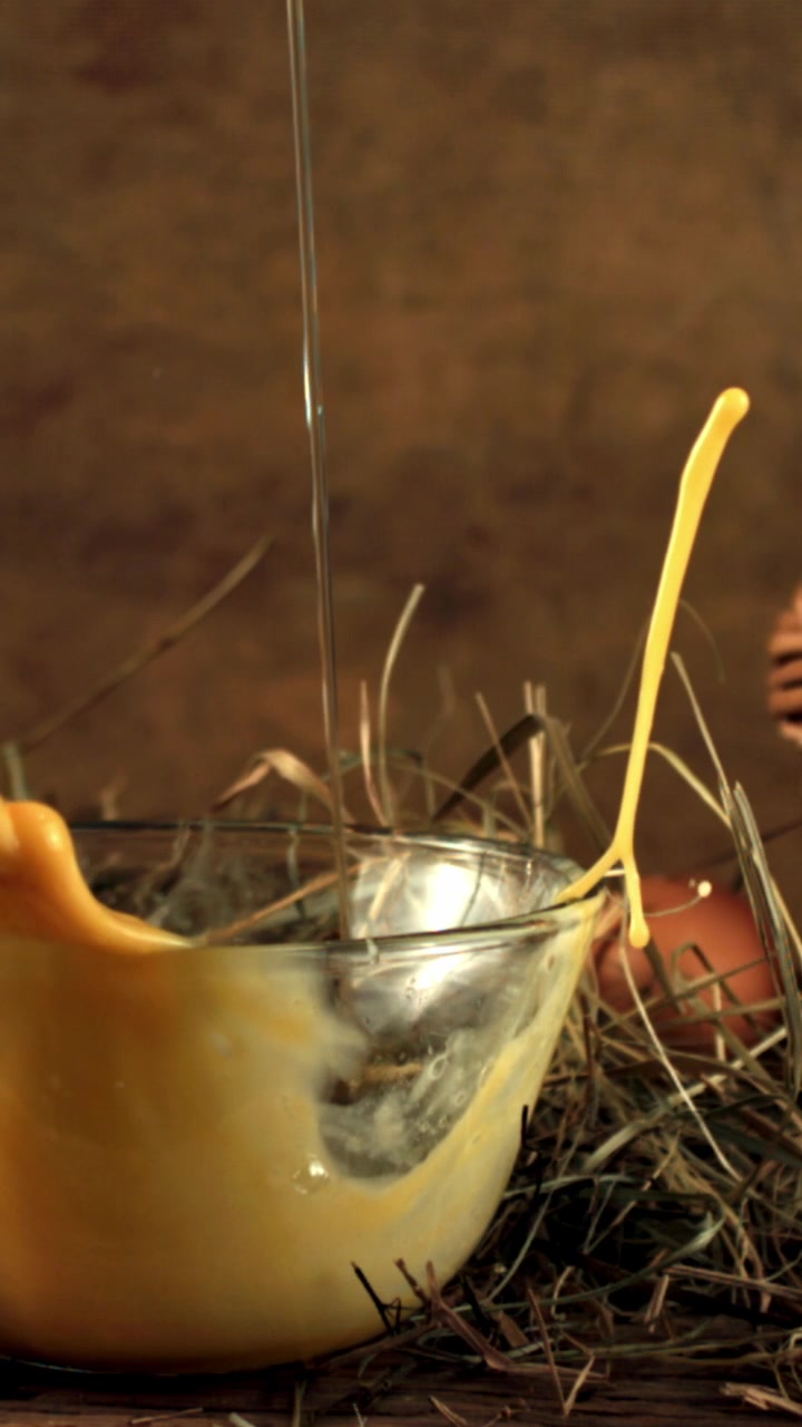 Egg Yolk and White Falling into a Glass Bowl in Slow Motion