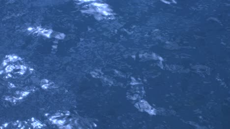 agua azul pura en el mar con reflejos de luz. superficie de agua azul que refleja el sol