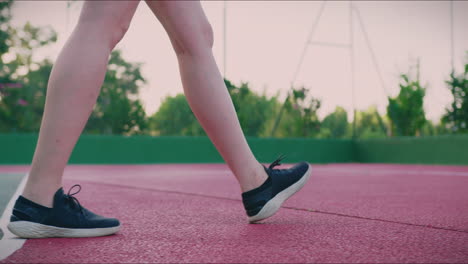 basketball court girl dribbles ball in slow motion low angle shot