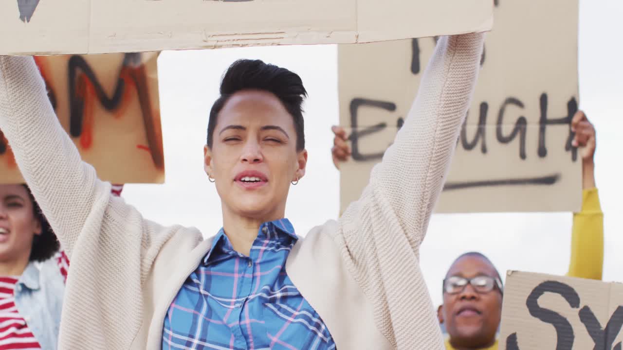 抗議者の多様なグループが紙板のバナーを掲げて叫んでいます