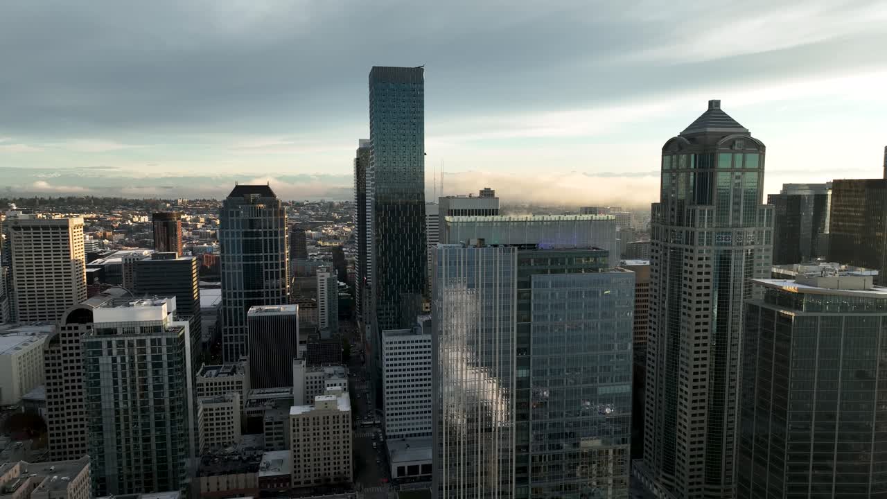 bajando la antena de los rascacielos de seattle reflejando la bahía de elliot y las olas de vapor en las ventanas