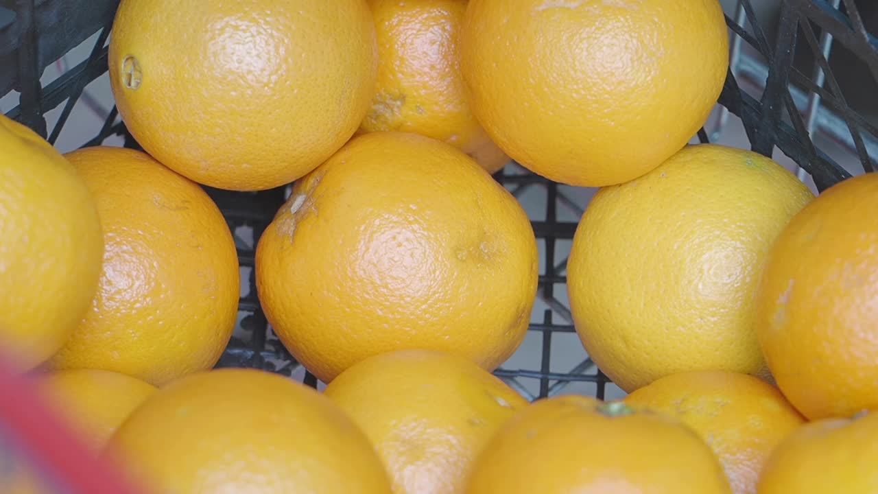 Person placing oranges in a crate