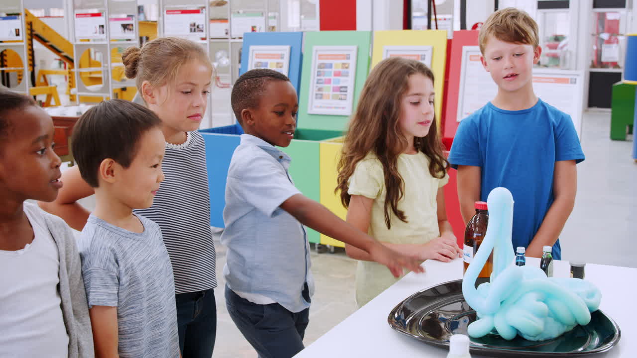 niños de escuela preguntando sobre la reacción química en el centro de ciencias