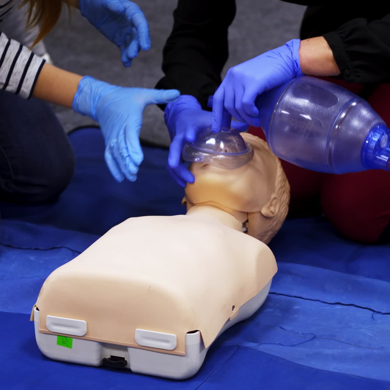 First medical help training equipment. Medical dummy lays on blanket . Practititoner puts oxygen mask. Educational courses for medics