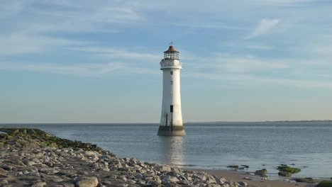 Coastal-low-tide-lighthouse-reflections-in-rocky-ocean-shore-waterfront