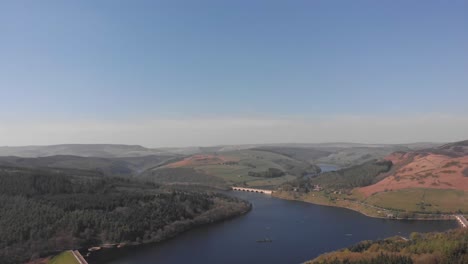 drone travelling rising with lady bower reservoir in view from bamford edge in the peak district shot in 4k