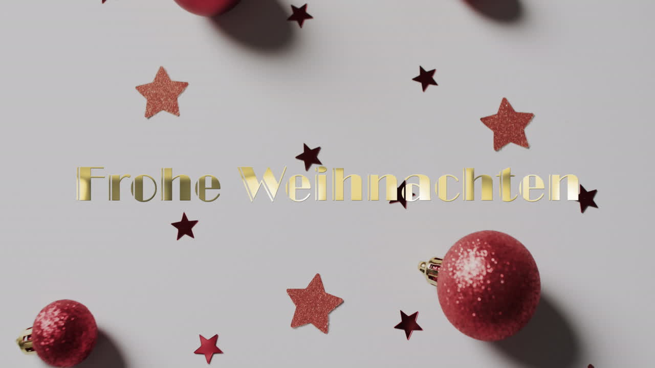Frohe Weihnachten Text in Gold mit roten Weihnachtskugeln und Sternen auf weißem Hintergrund