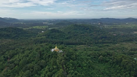 phra maha chedi thep nithakorn estupa dorada sobre una colina del bosque en la provincia de saraburi, tailandia