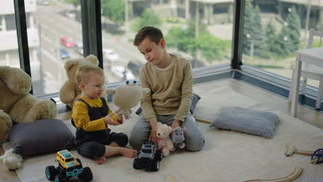 Zwei-Brüder-Spielen-Mit-Stofftieren.-Entzückende-Kinder,-Die-Zu-Hause-Auf-Dem-Teppich-Sitzen.