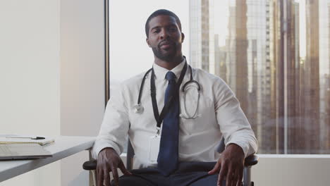 Portrait-Of-Smiling-Male-Doctor-With-Stethoscope-In-Hospital-Office