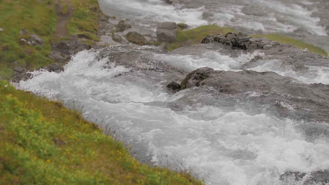 Slow motion-optagelse af en lille bæk, der strømmer i Island